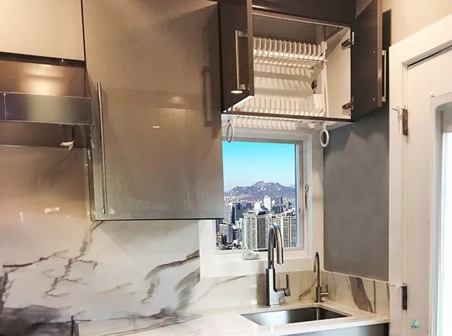Dry dishes over sink at window in cabinet